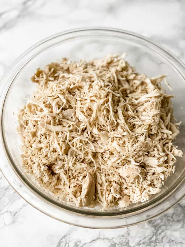 cooked shredded chicken in a glass bowl