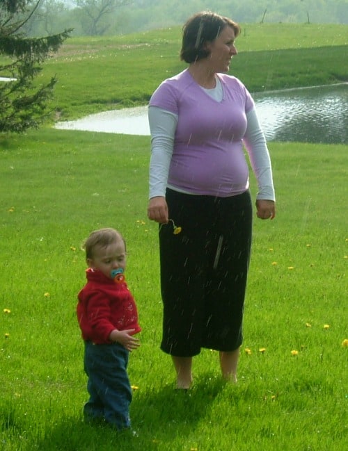 Woman in purple top holding a flower next to a toddler.