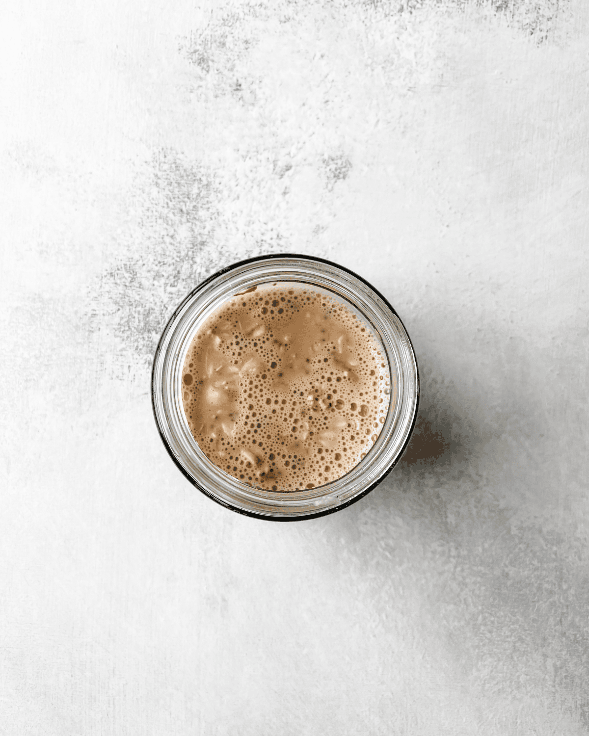 overhead picture of liquid and dry ingredients mixed together in a mason jar.