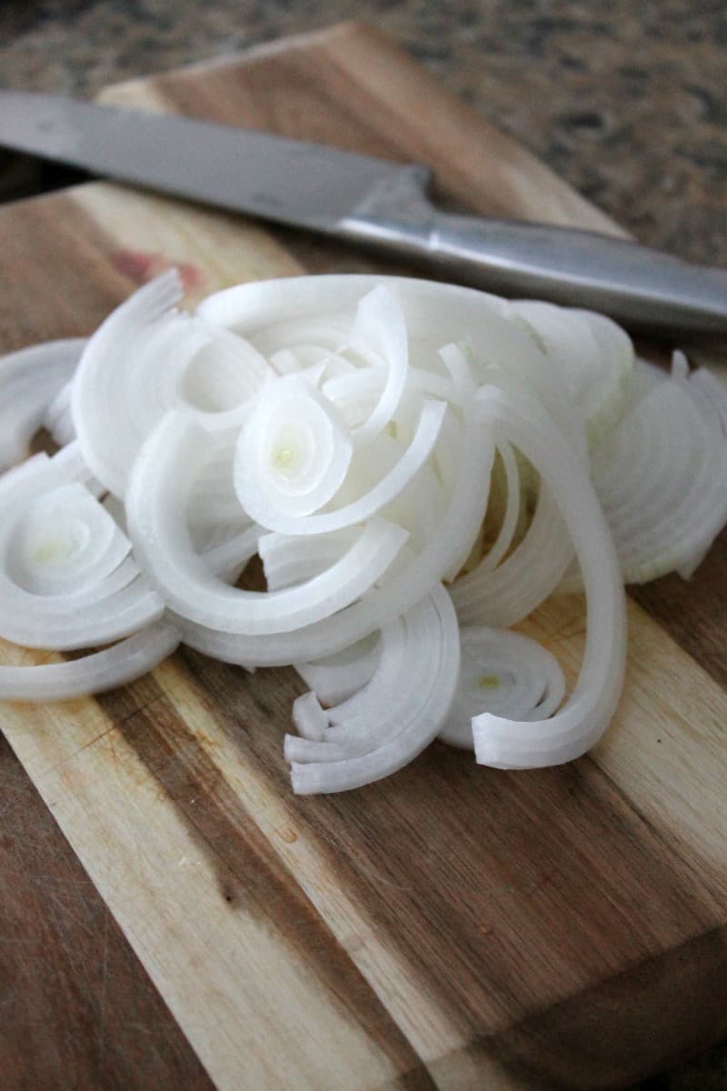 Onions chopped on a wooden cutting board for meal prep.