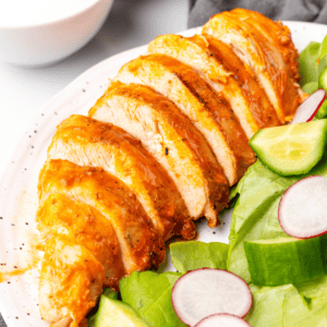 buffalo grilled chicken sliced on a plate.