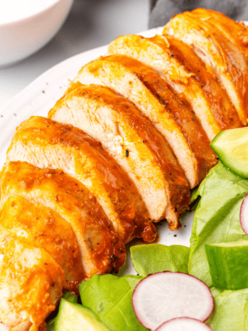 buffalo grilled chicken sliced on a plate.