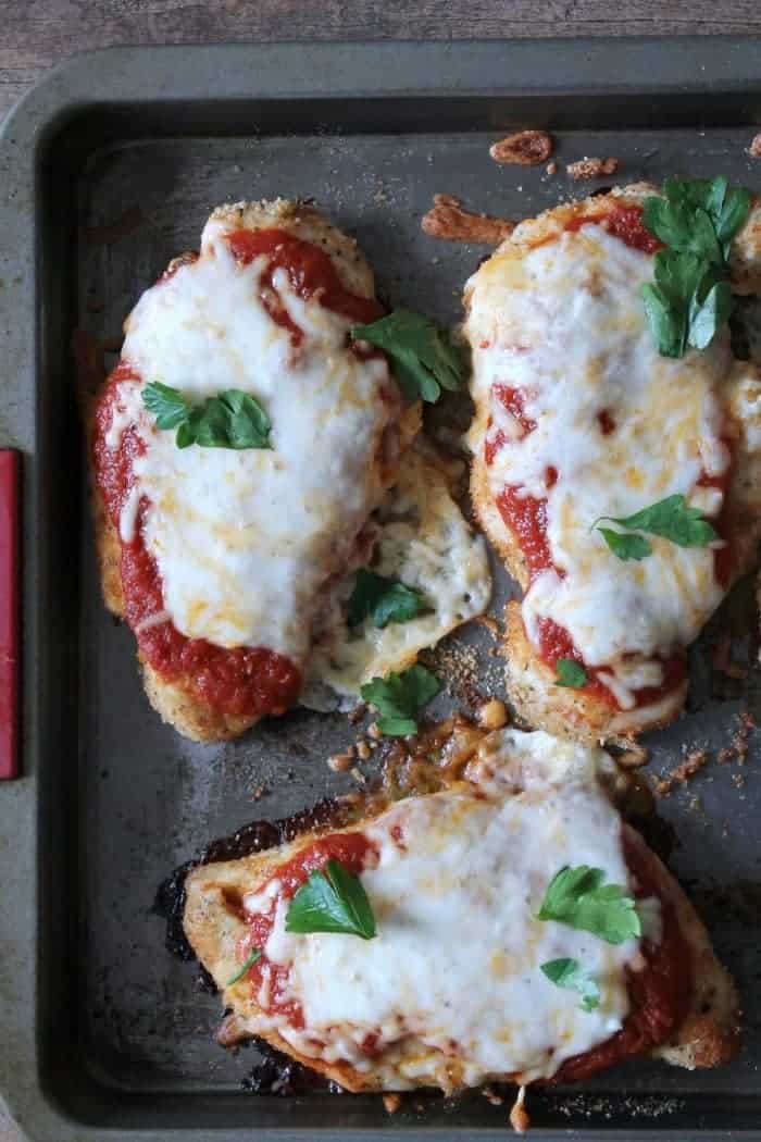 Healthy Baked Chicken Parmesan Recipe made and baked on a gray cookie sheet.