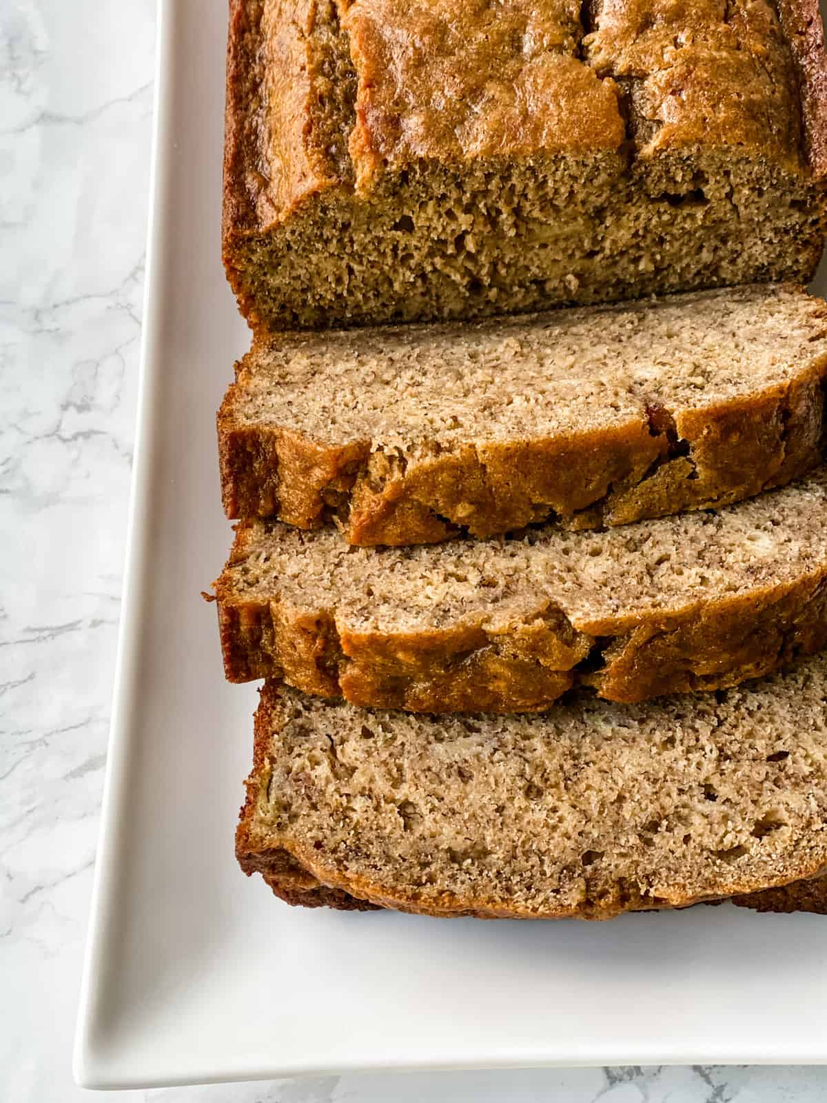 healthy banana bread recipe sliced on a platter.