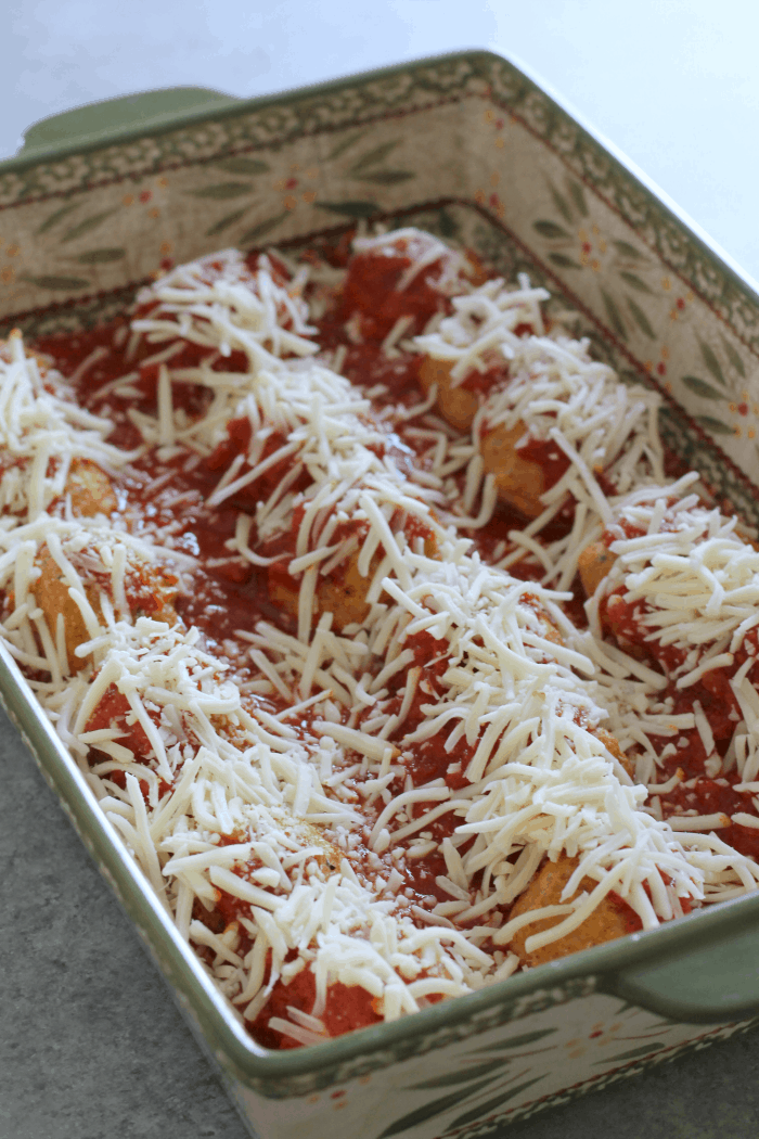 chicken parmesan meatballs with sauce and cheese sprinkled on top.