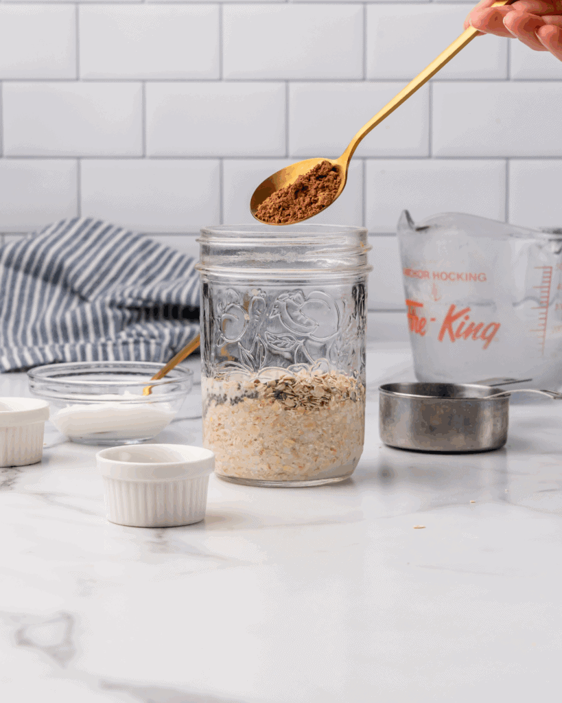 adding the dry ingredients into a mason jar for banana overnight oats.