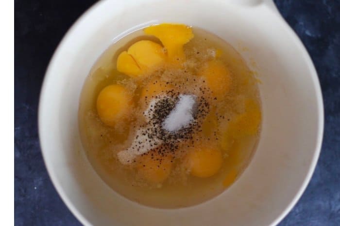 Easy breakfast ideas with eggs - raw eggs being made in a white bowl
