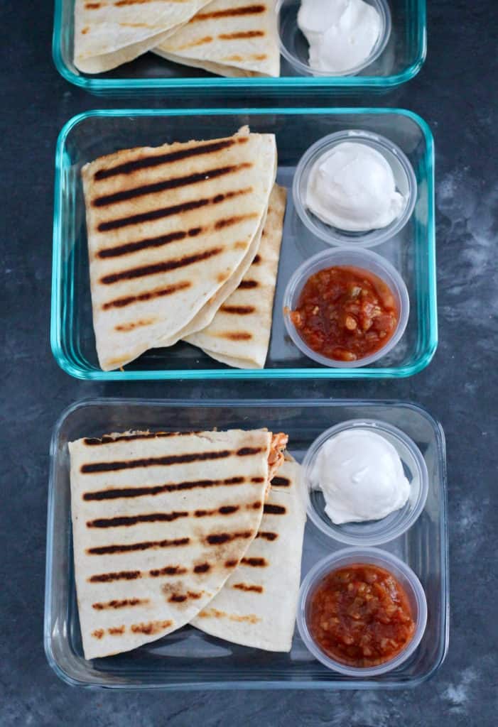 Easy meal prep for the week is shown with a row of grilled quesadillas in glass containers.