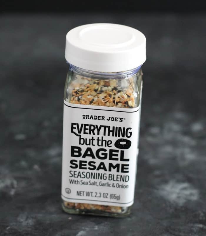 A jar of Everything But The Bagel seasoning with a gray background. 