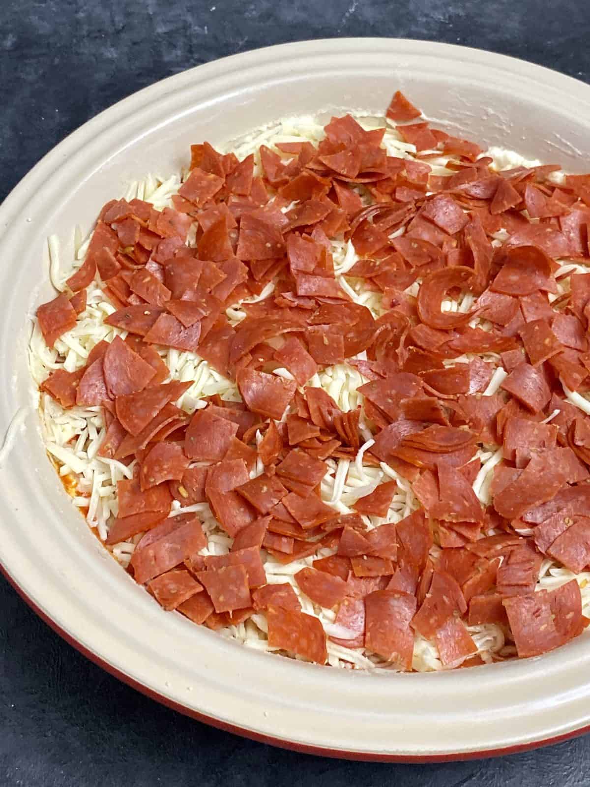 Pepperoni dip in a baking dish prior to going into the oven.