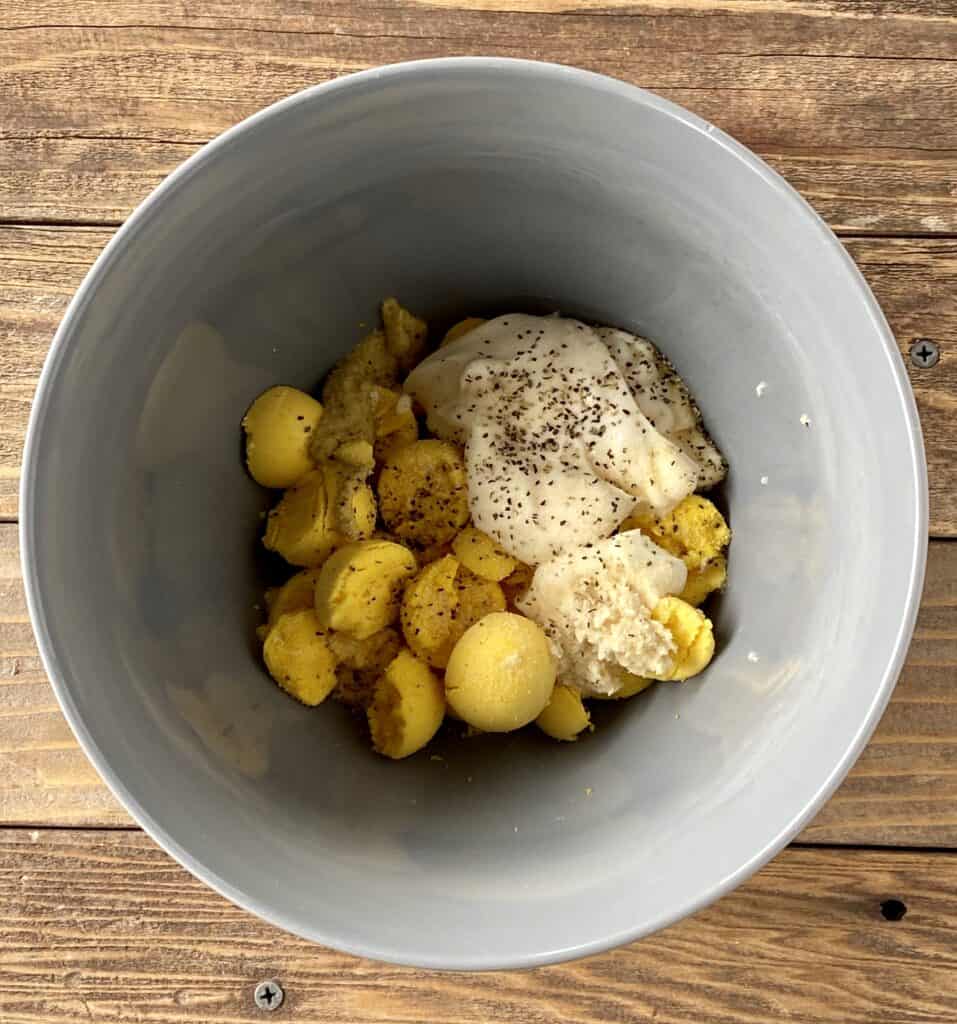 making horseradish deviled egg filling in a bowl 