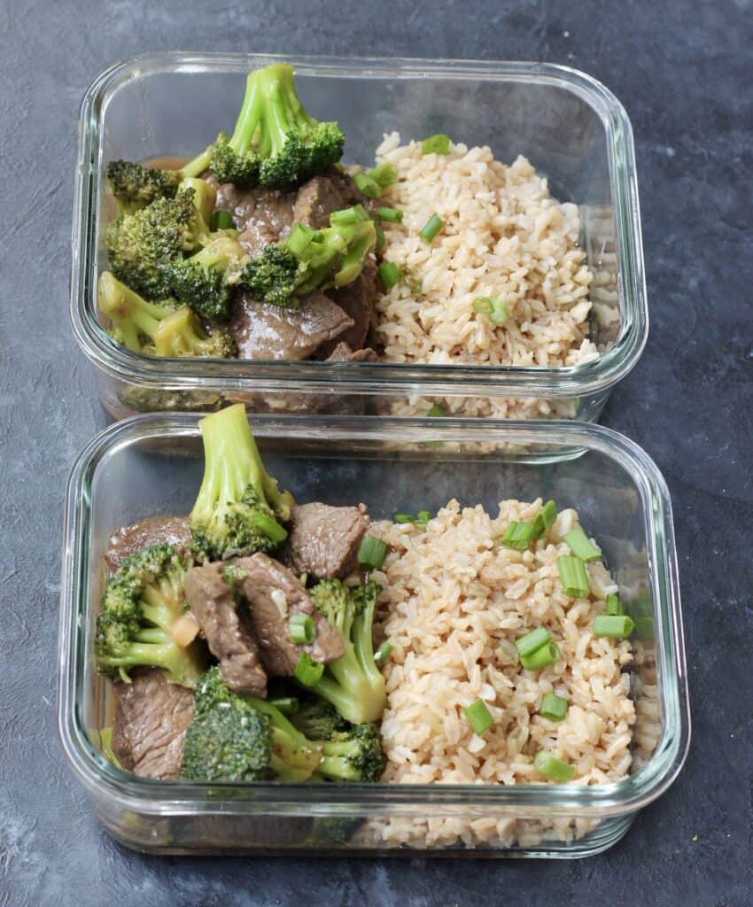 Individual glass container with brown rice and beef and broccoli stir fry.