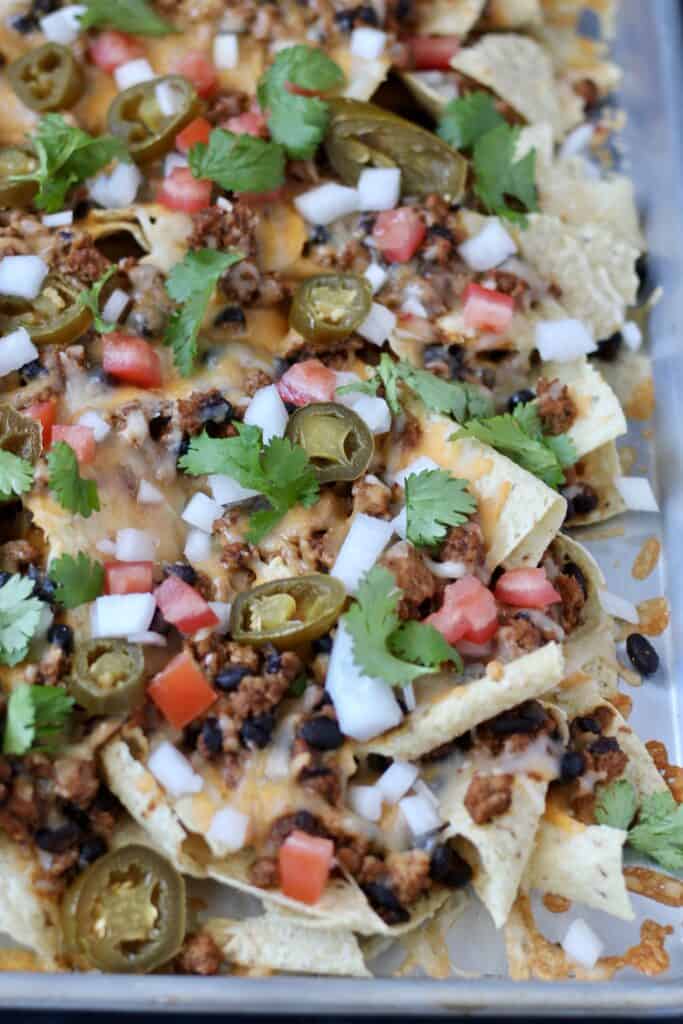 Close up of ground turkey nachos with toppings.