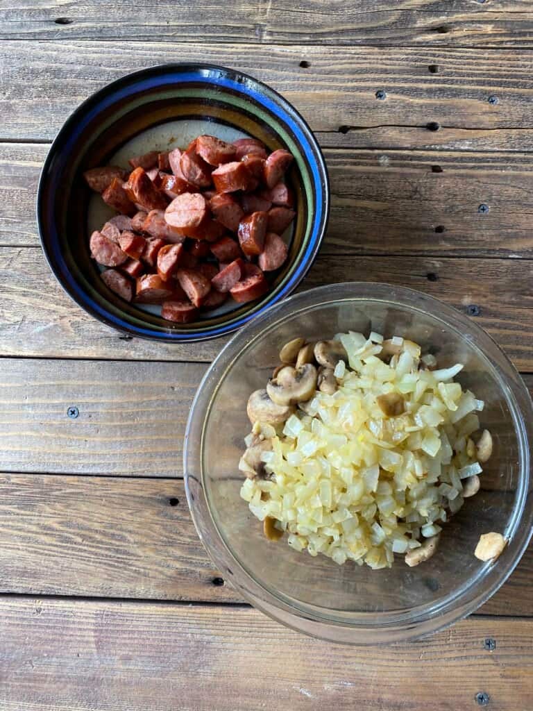 Bowls of sliced sausage and onions for freezer casseroles