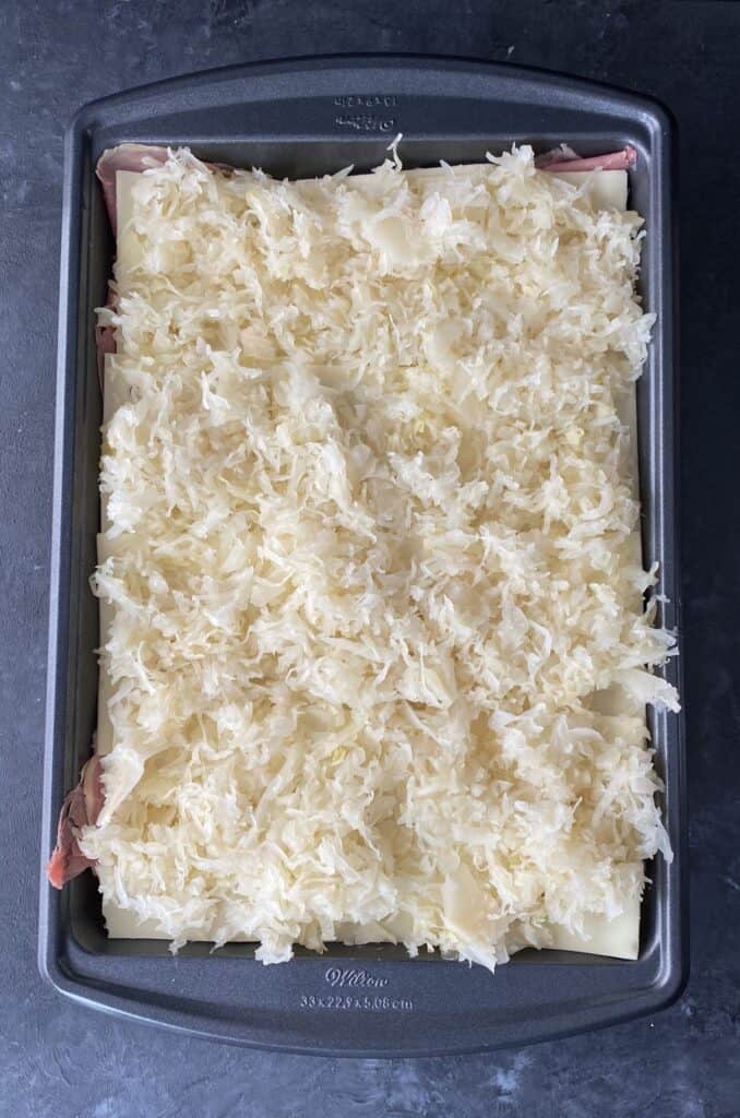 sauerkraut on top of corned beef and swiss cheese to make reuben sliders
