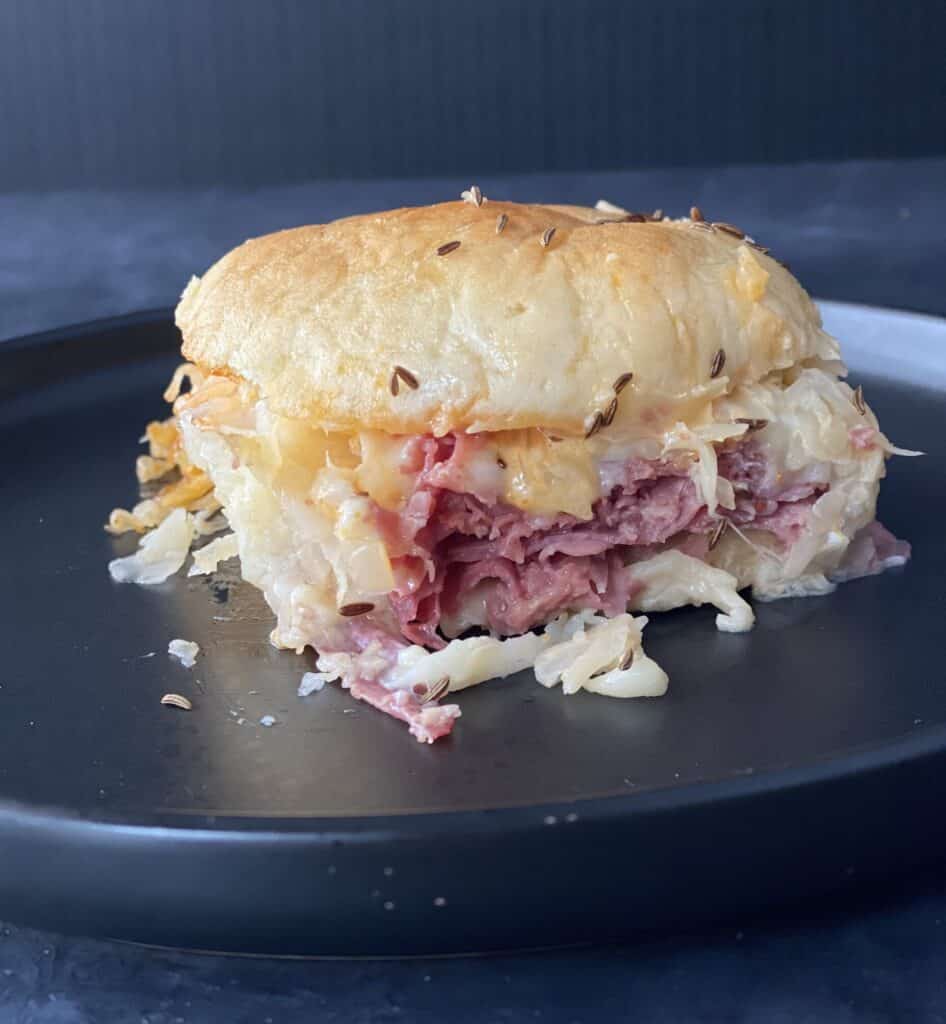 Baked reuben slider on a dark colored plate