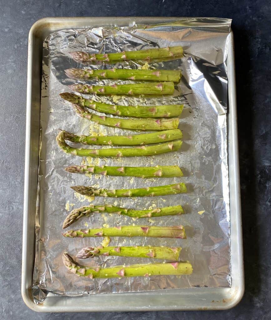 seasoned asparagus on foiled pan