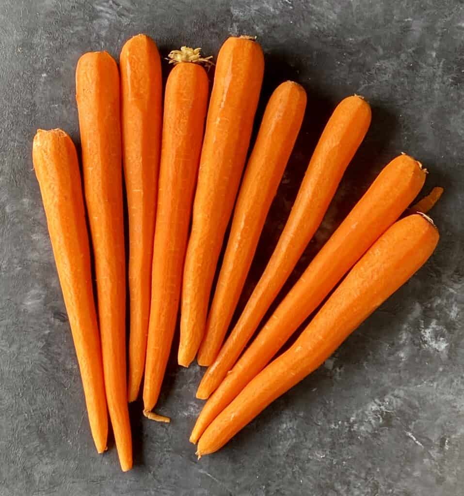 peeled carrots on gray table