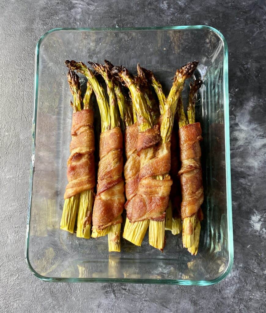 bacon wrapped asparagus in a glass container for meal prep
