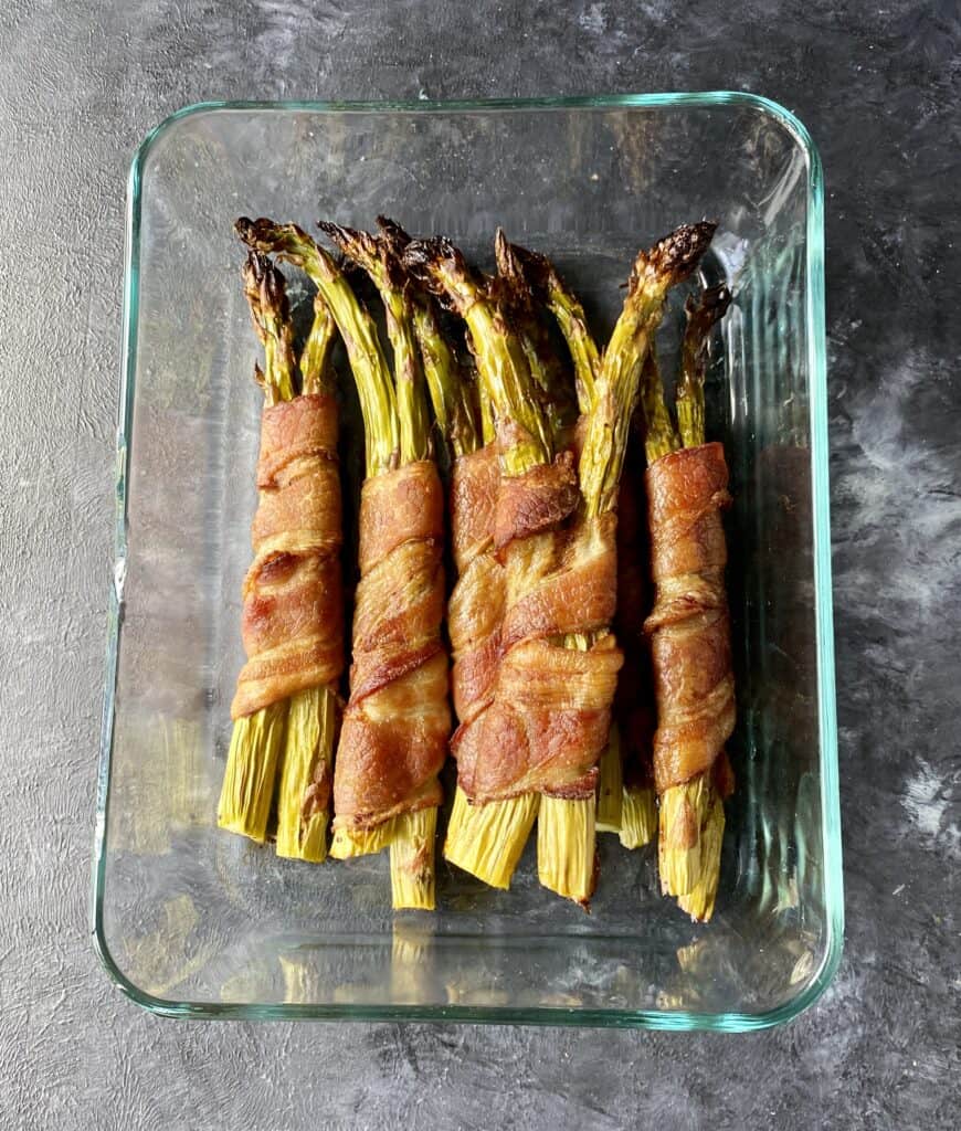 bacon wrapped asparagus in a glass container for meal prep