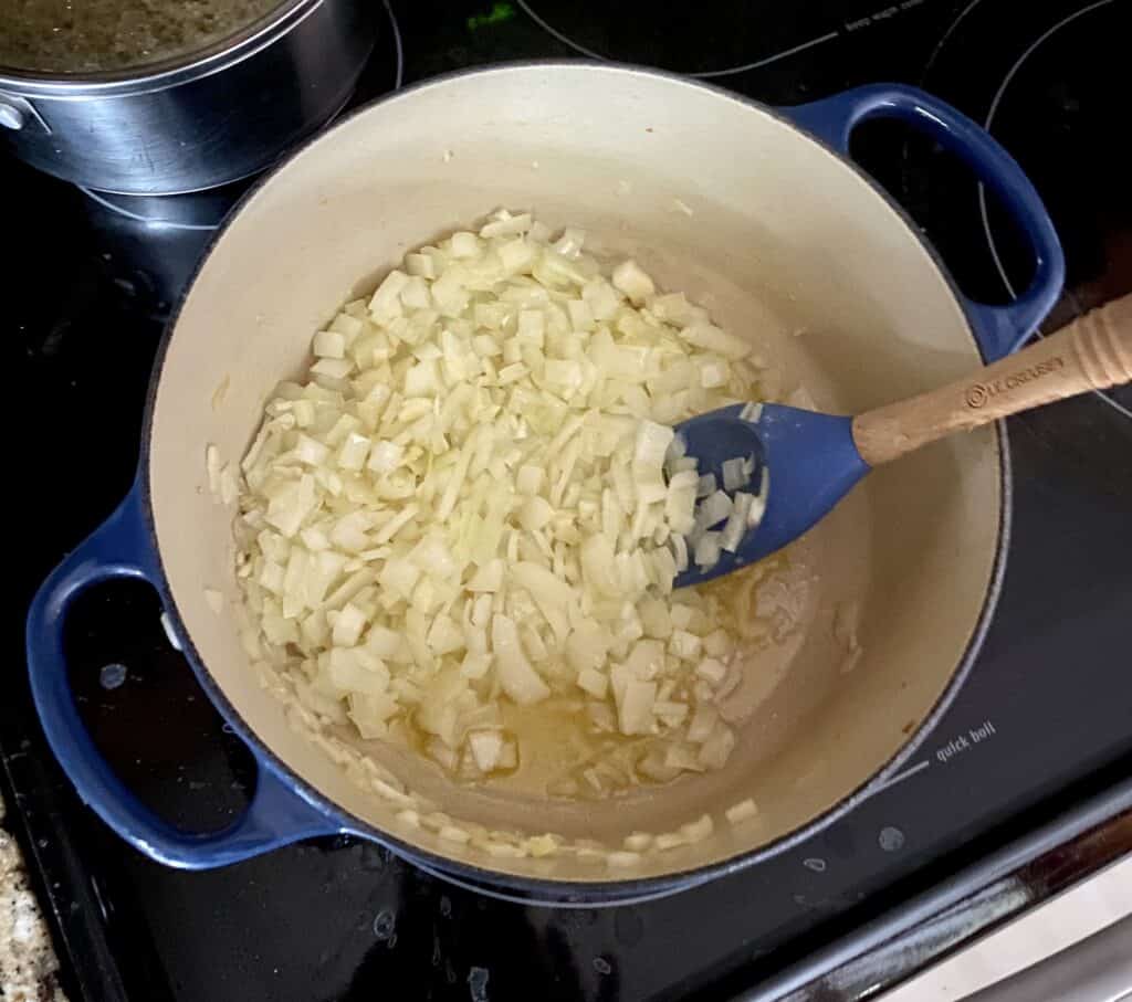 onions cooking in a blue pot