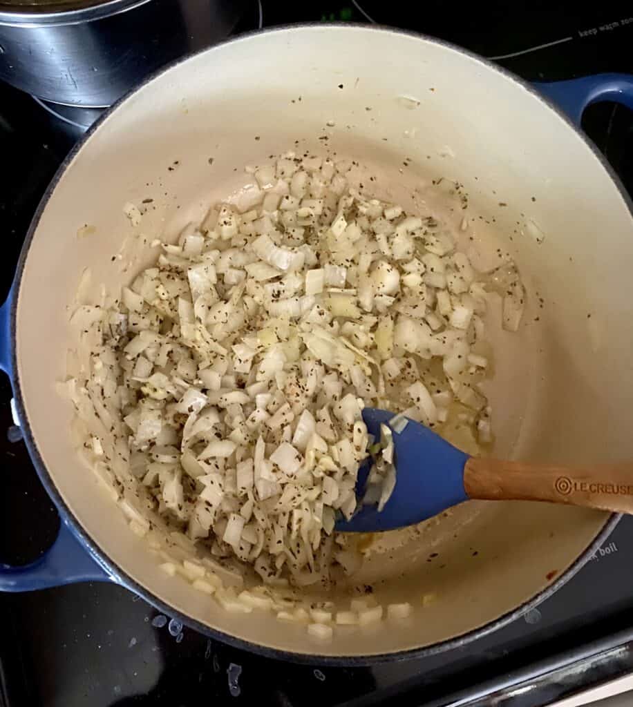 Cooking diced onions and seasoning as a base for marinara sauce