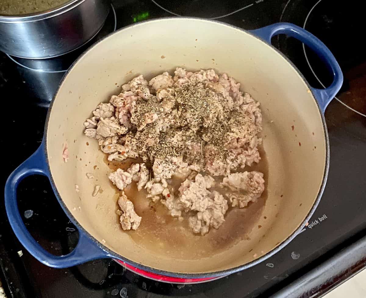 Ground turkey with seasoning being cooked on a stovetop