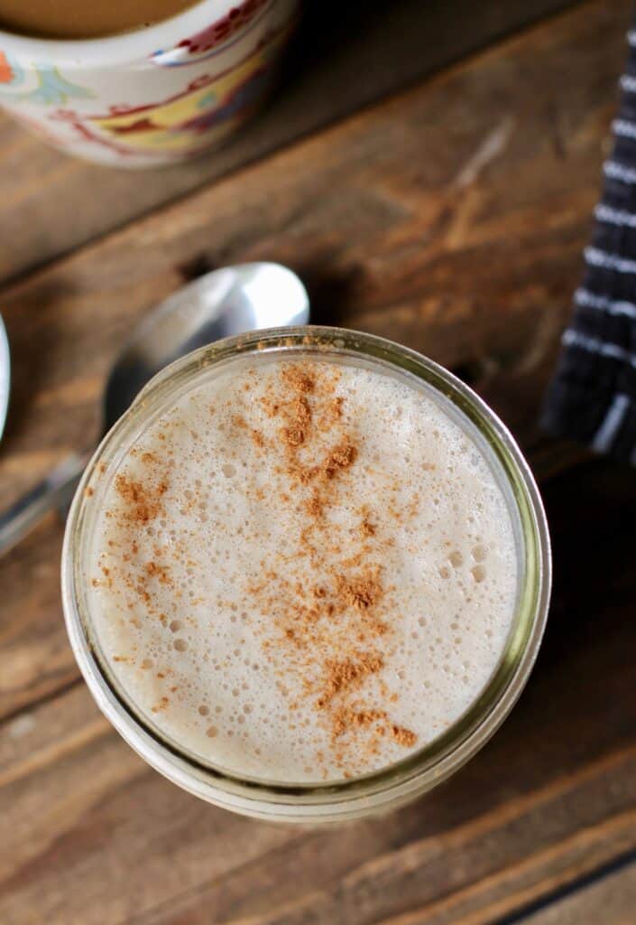 Close up of a glass jar filled with a frothy vegan creamer