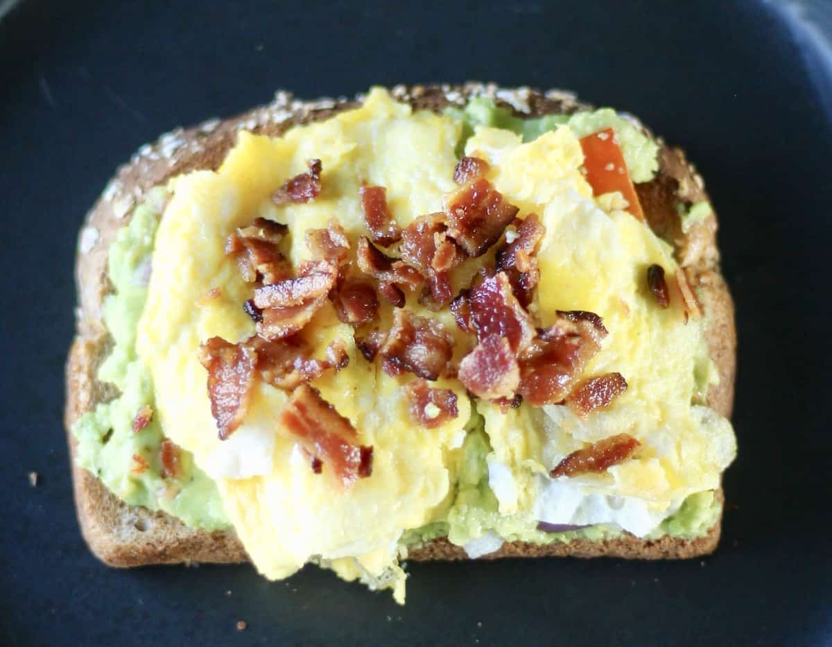 avocado toast topped with egg and bacon as a high protein breakfast idea