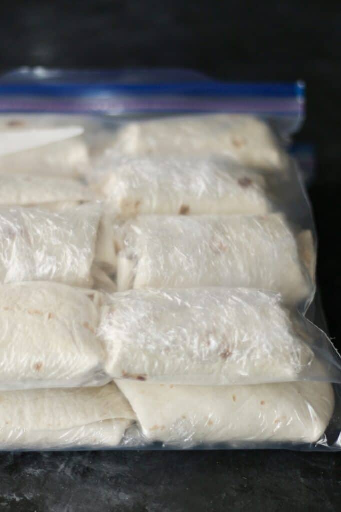 Breakfast burritos wrapped in plastic and stored in ziplock bags, ready to freeze