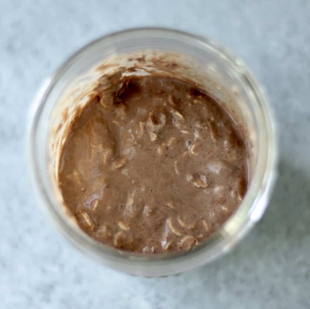 Overhead view of chocolate overnight oats with yogurt in a jar