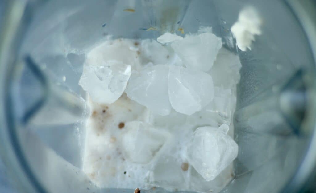 Looking down into a blender filled with milk and ice