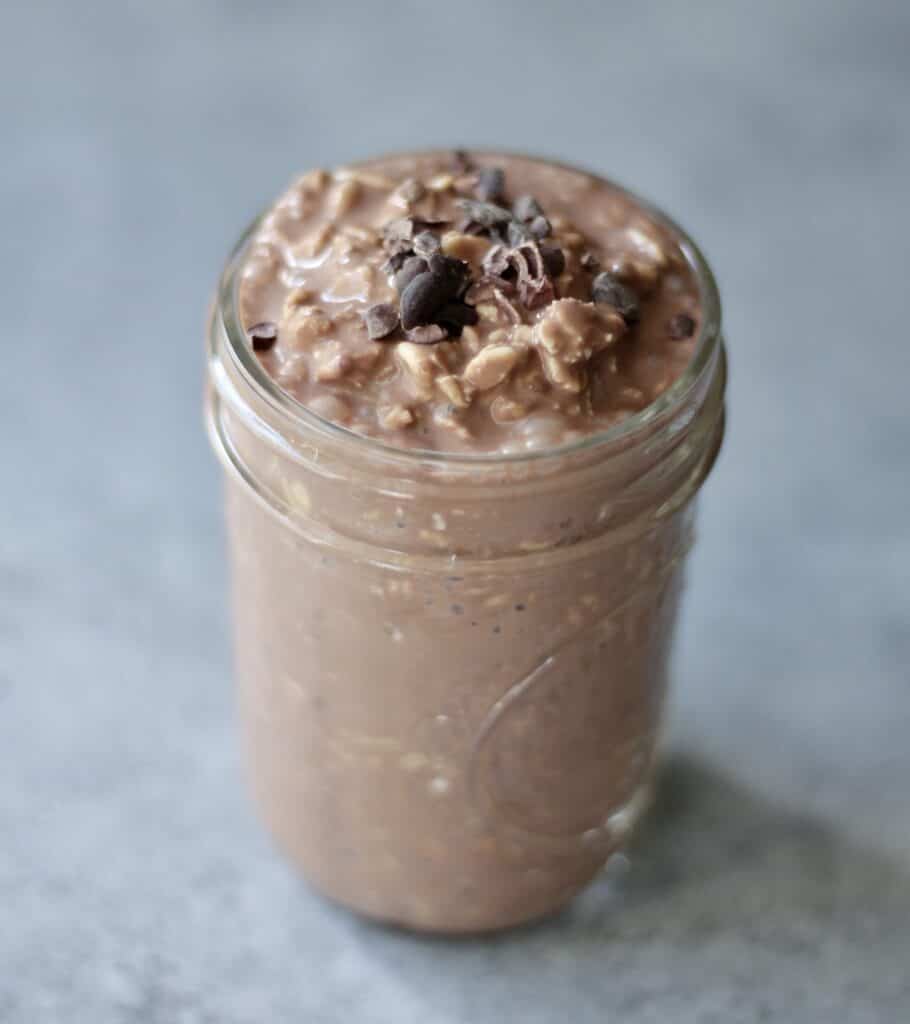 Creamy chocolate overnight oats with yogurt in a mason jar.