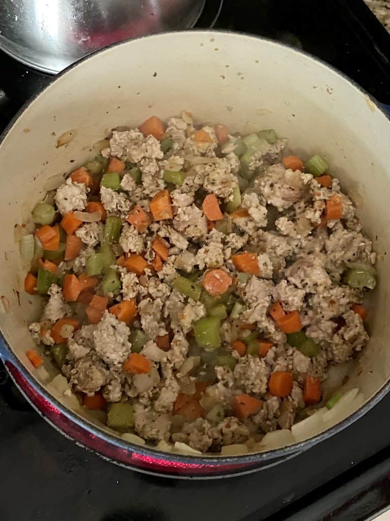 cooked ground turkey with onions, garlic, and celery in a soup pot 