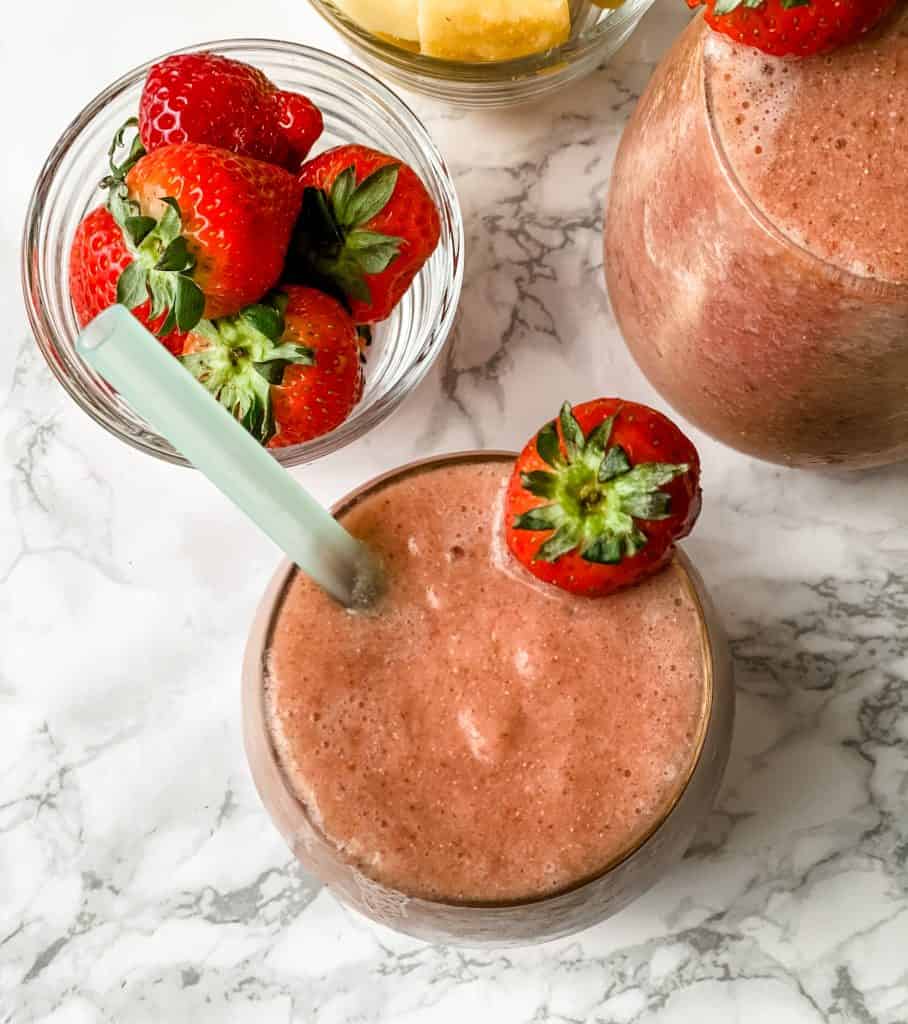 Smoothie in a mason jar with strawberries on the side