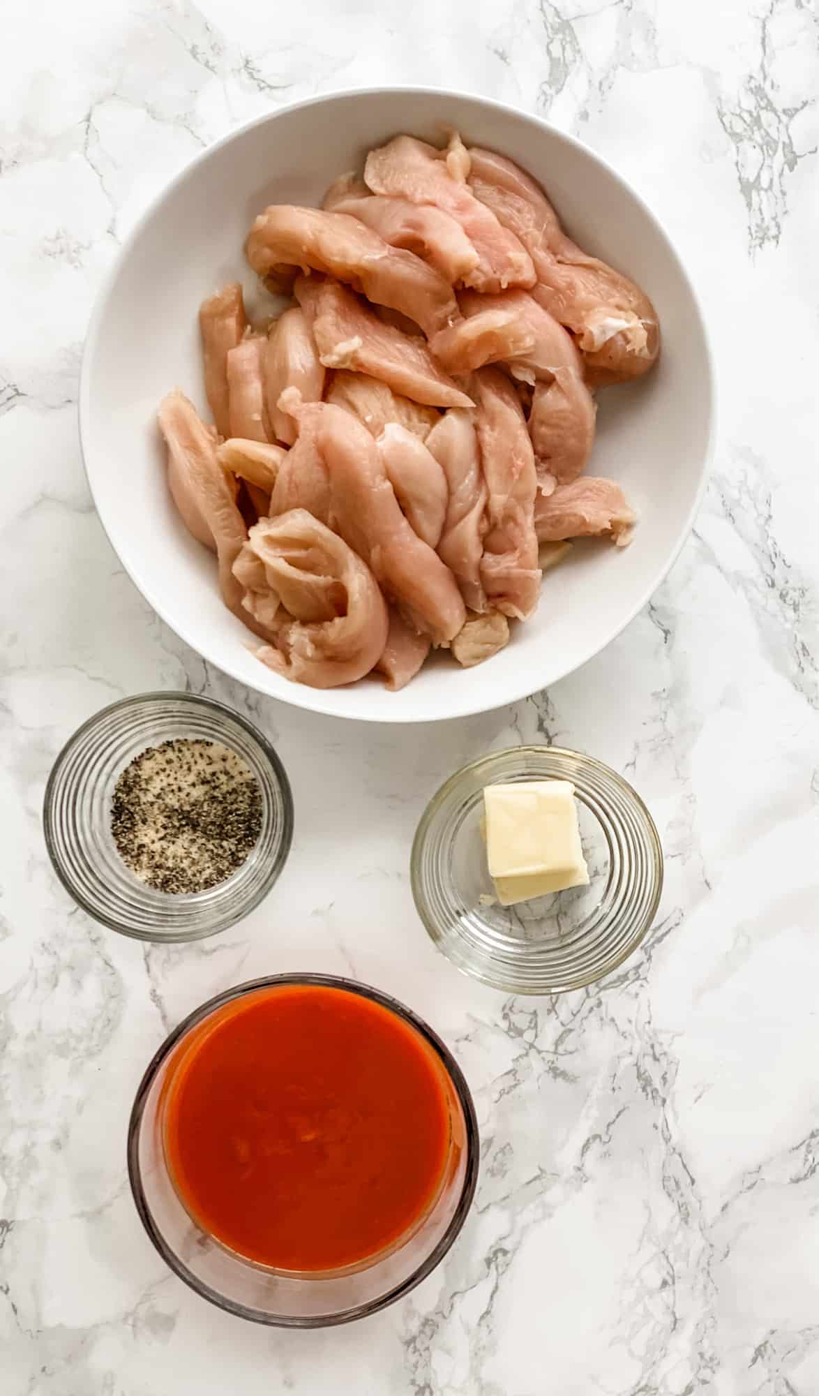 ingredients for buffalo chicken wrap. buffalo tenders, seasoning, hot sauce, and butter.