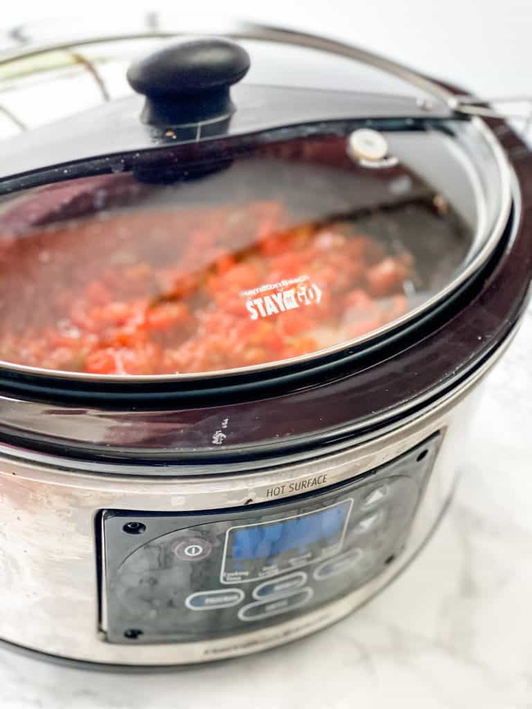 slow cooker with salsa and chicken inside