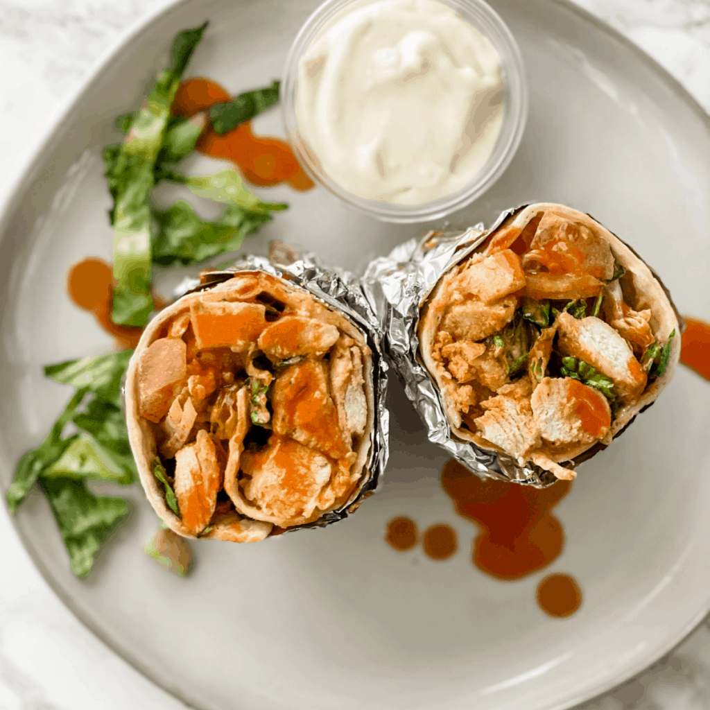 buffalo chicken wrap with a side of blue cheese on a plate.