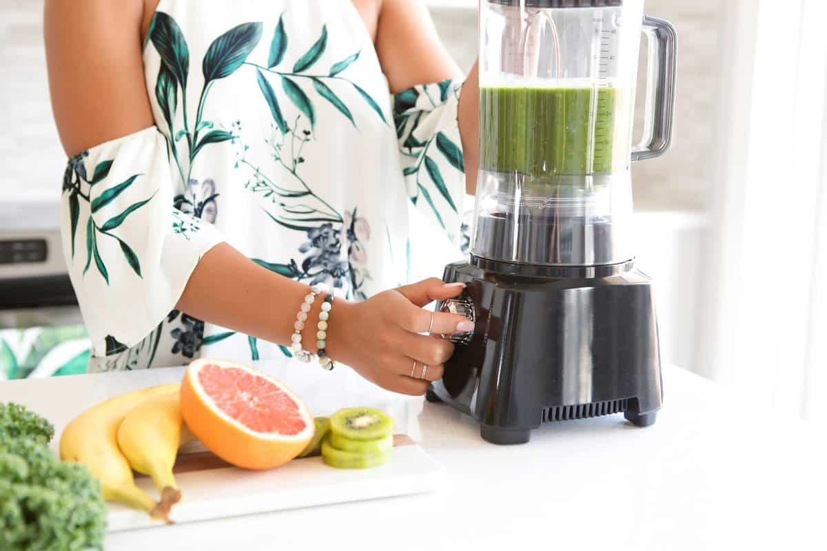 woman making a green smoothie.