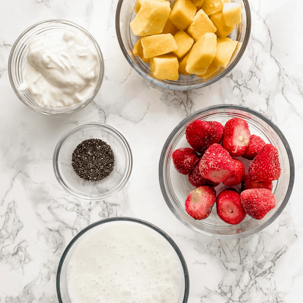 Ingredients to make a strawberry and mango smoothie