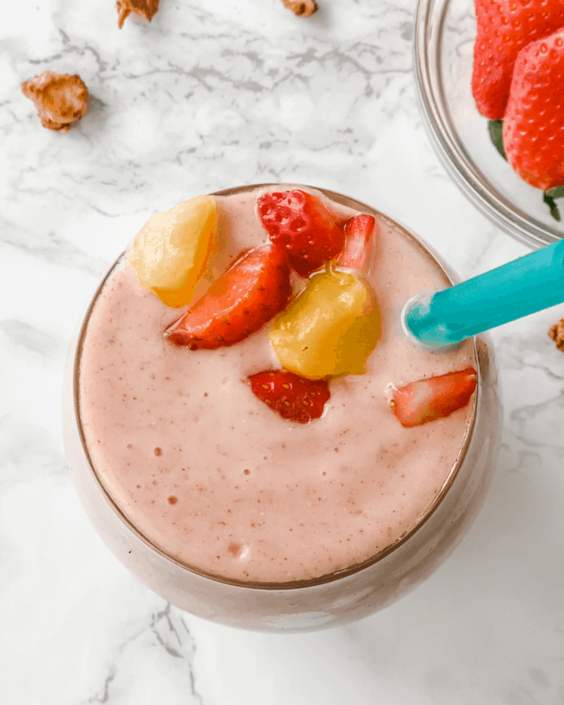 A picture of a strawberry mango smoothie from the top of a glass