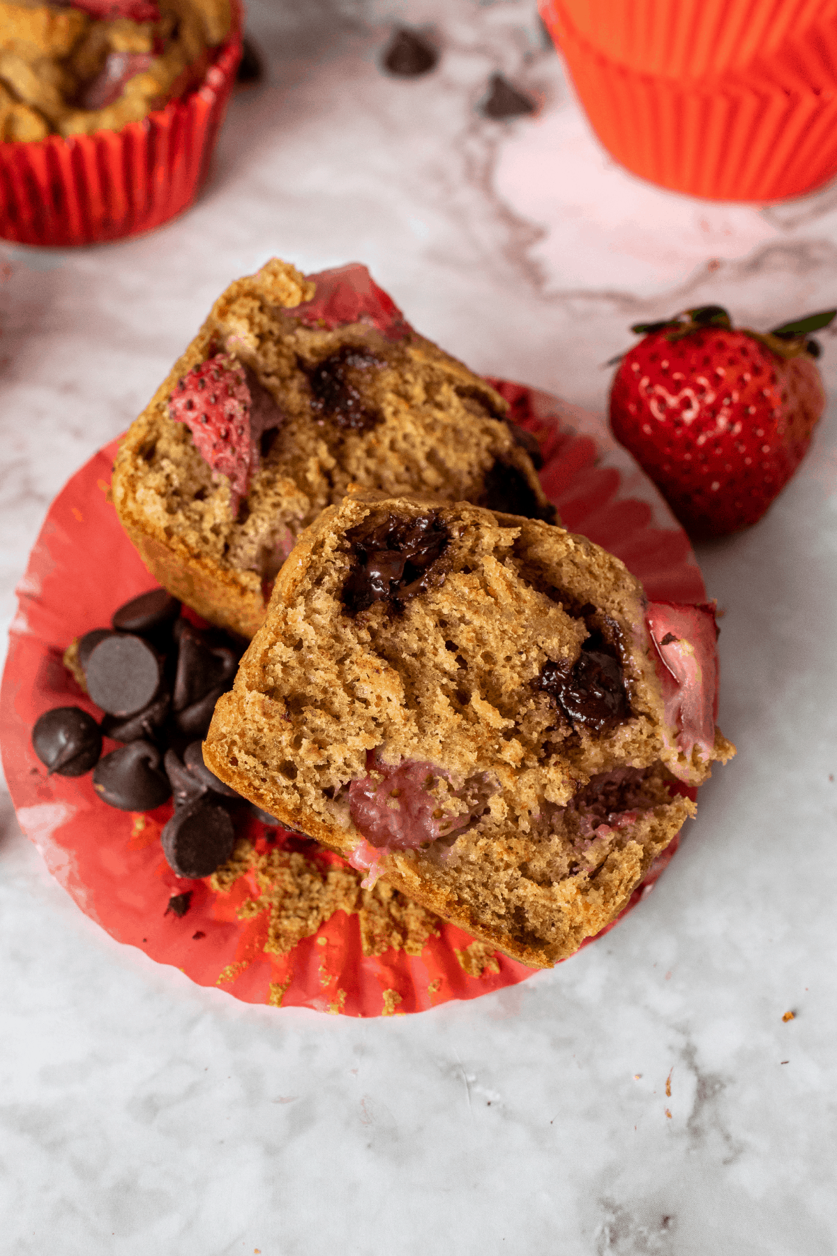 Strawberry chocolate chip muffins cut in half showing the inside.