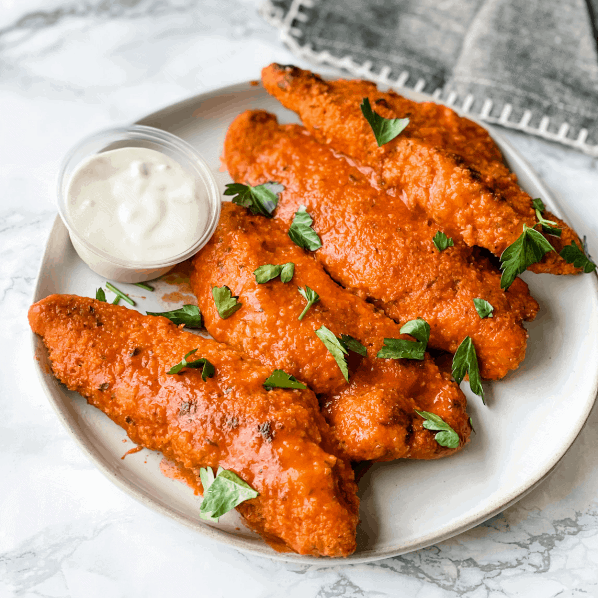 Baked Buffalo Chicken tenders. Healthy chicken tenders baked till crispy and then tossed in a delicious buffalo sauce. 