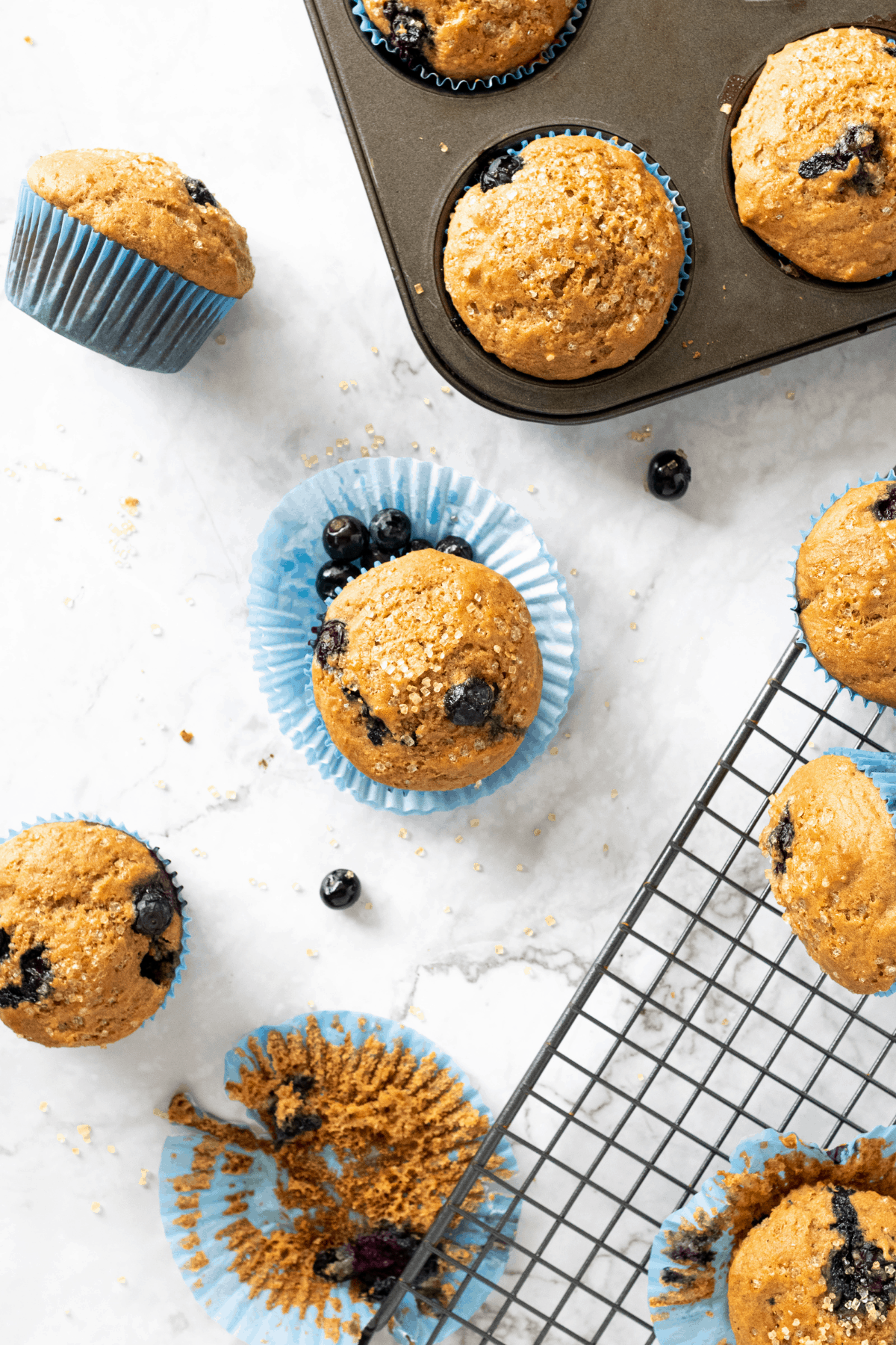 healthy blueberry Greek yogurt muffins in a pan and on a wire cooling rack.