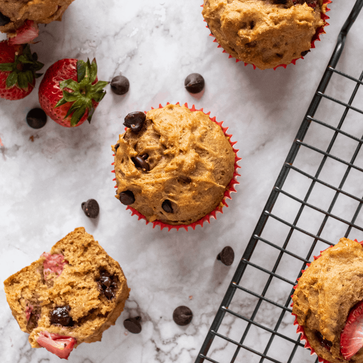 healthy Strawberry chocolate chip muffins next to strawberries.