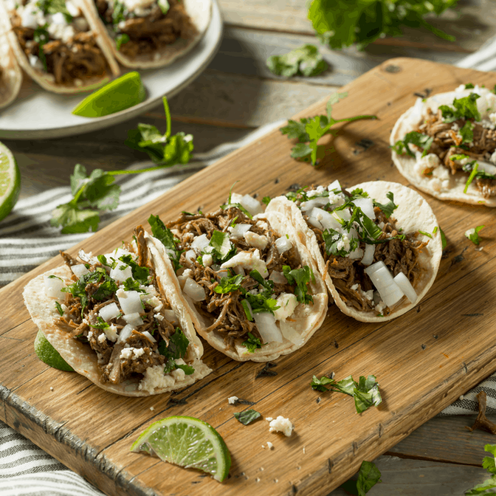 shredded pork tacos with onions and cilantro on top.