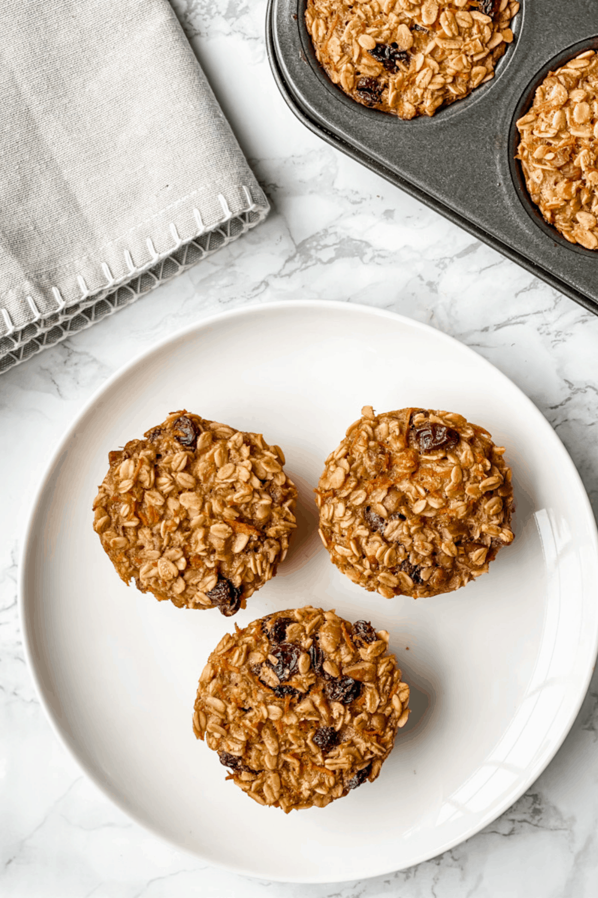 three baked carrot cake baked oatmeal cups on a plate.