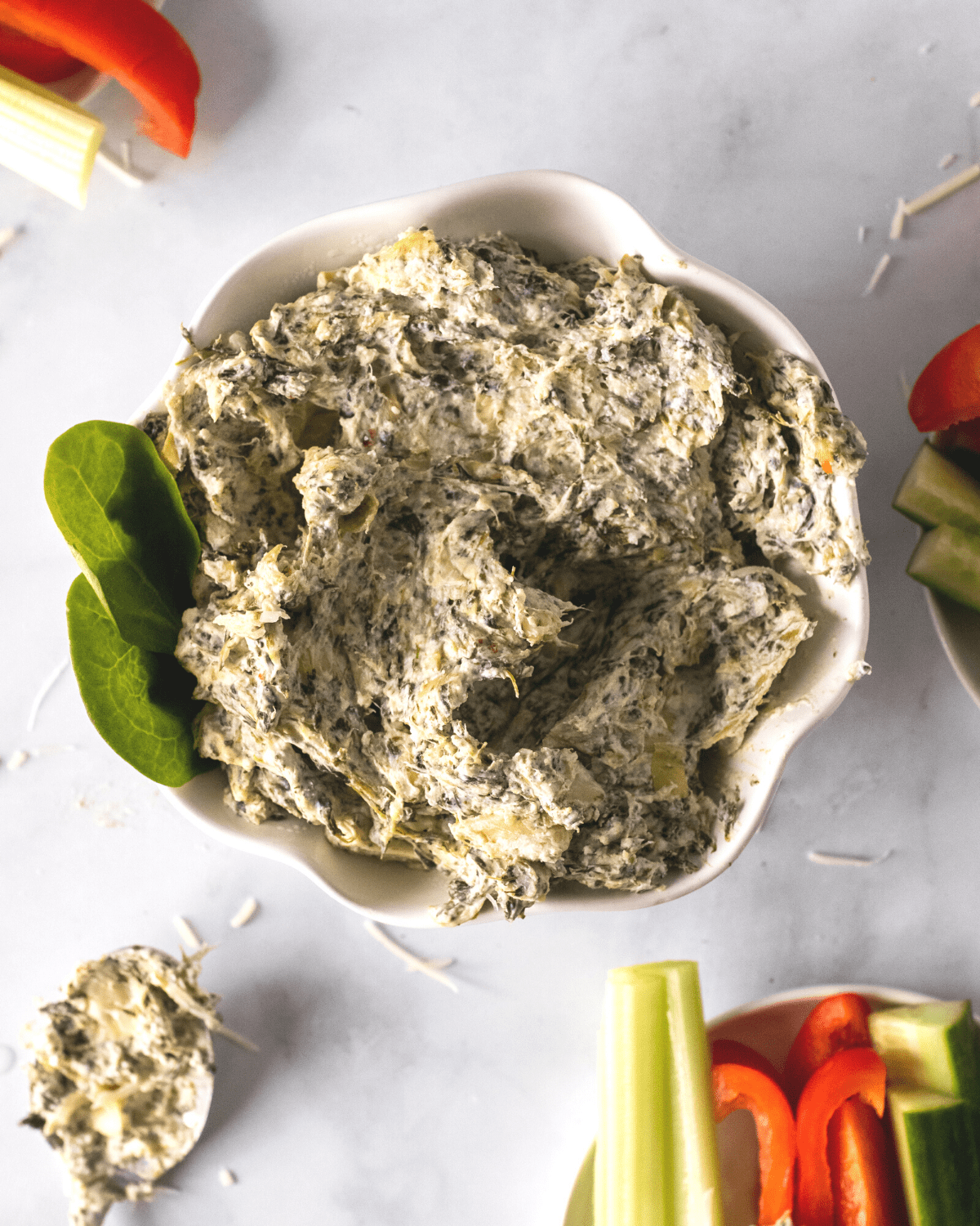 healthy spinach artichoke dip in a dish with veggies