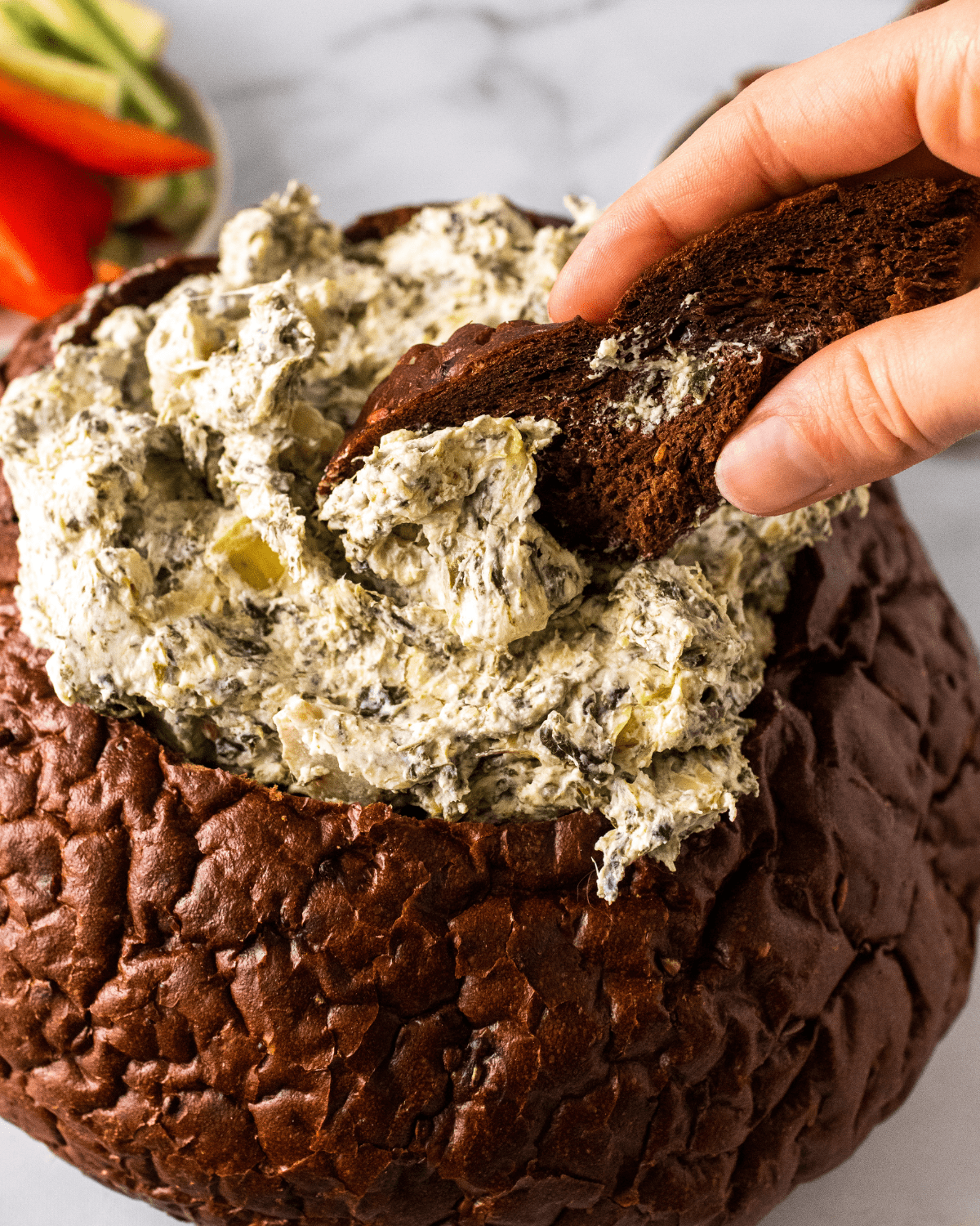 healthy spinach artichoke dip in a bread bowl