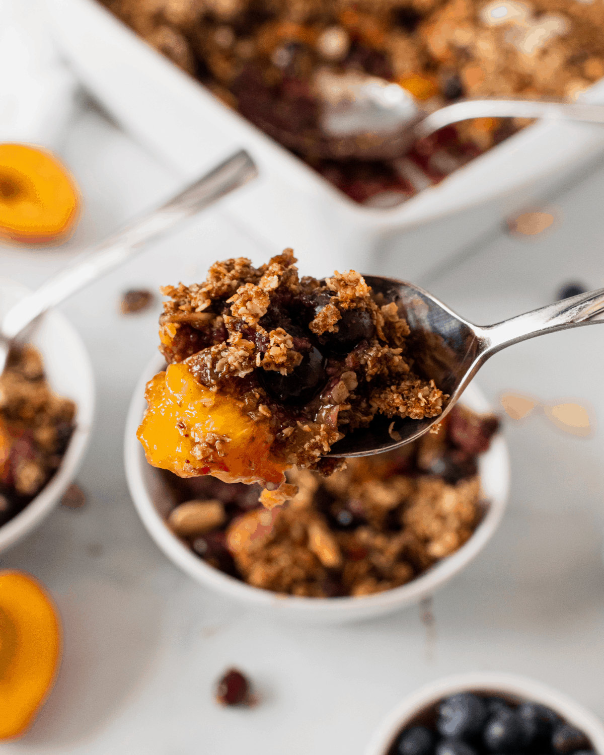 A closeup shot with the healthy blueberry peach crisp on a spoon.